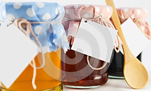 A jar with honey, mulberry and flower jam on a white background