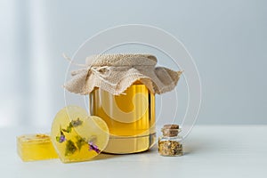 Jar with honey near handmade soap