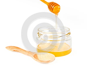 Jar of honey with wooden drizzler