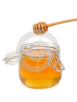 Jar of honey with wooden drizzler photo
