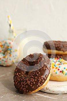 Jar of milk and tasty donuts on gray table