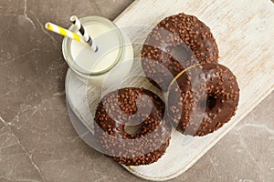 Jar of milk and tasty donuts on gray table