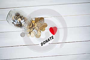 Jar with money on white wood background. Donate conception