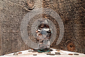 Jar overflowing with coins as a savings for retirement or a college fund concept.