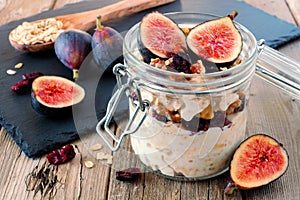 Jar of overnight autumn oats with figs, cranberries and walnuts
