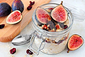 Jar of overnight autumn oats with figs, cranberries and walnuts