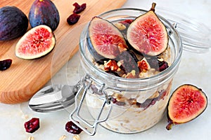 Jar of overnight autumn oats with figs, cranberries and walnuts photo
