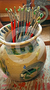 Jar of paintbrushes with cobwebs