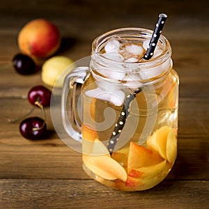 Jar of Peach Ice Tea with Fresh Fruits on a Rustic Wooden Background Tasty Fresh Summer Drink Square