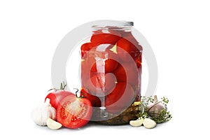 Jar of pickled tomatoes and fresh ingredients on background