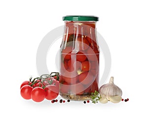 Jar of pickled tomatoes and fresh ingredients on white background