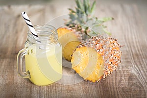 A jar of pineapple juice with a raw pine apple