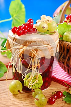 Jar of preserve with fresh red,white currant and gooseberry