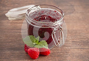 Jar of Raspberry Jam on a Rustic Wooden Table