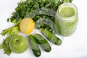 Jar of raw green vegetable smoothie juice with lemon, cucumbers, apple, apio and parsley, on white background photo