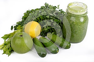 Jar of raw green vegetable smoothie juice with lemon, cucumbers, apple, apio and parsley, on white background photo