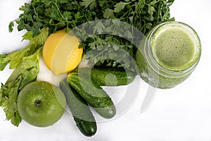 Jar of raw green vegetable smoothie juice with lemon, cucumbers, apple, apio and parsley, on white background photo