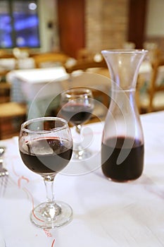 A jar of red wine and two glasses.