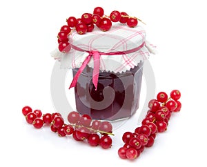 Jar of redcurrant jam with fresh redcurrants