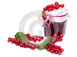 Jar of redcurrant jam with fresh redcurrants and mint