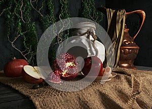 jar, rop, apples,pomegranate,plant and orange on canvas drapery conceptual still-life