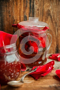 Jar of rose petal jam on a wooden table