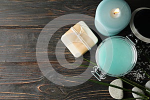 Jar with scrub and spa supplies on wooden background