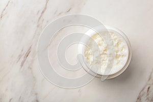 Jar of shea butter and space for text on marble background