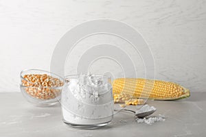 Jar and spoon with corn starch on table