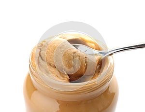 Jar and spoon with creamy peanut butter