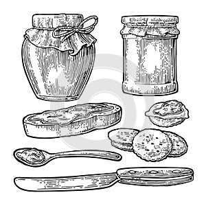 Jar, spoon, knife and slice of bread with jam.