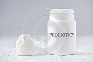 A jar and spoon with probiotic powder on gray photo