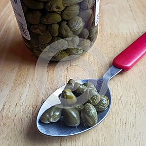 Jar and spoonful of Turkish Capers