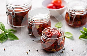 Jar with sun dried tomatoes with fresh herbs and spices