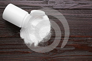 Jar of sweet powdered fructose on black wooden table, top view. Space for text