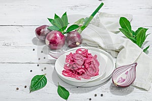 Jar with tasty pickled onions on black table. Cutlery, served meal ready to eat, trendy stand