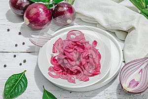 Jar with tasty pickled onions on black table. Cutlery, served meal ready to eat, trendy stand