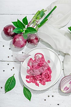 Jar with tasty pickled onions on black table. Cutlery, served meal ready to eat, trendy stand