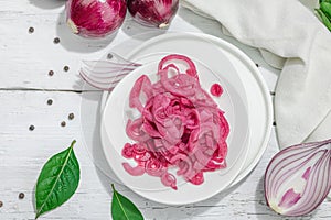 Jar with tasty pickled onions on black table. Cutlery, served meal ready to eat, trendy stand