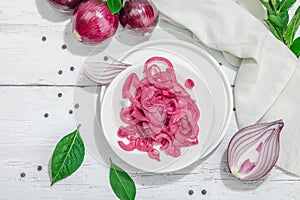 Jar with tasty pickled onions on black table. Cutlery, served meal ready to eat, trendy stand