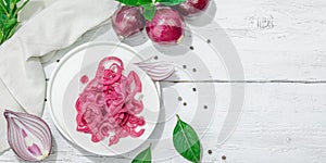 Jar with tasty pickled onions on black table. Cutlery, served meal ready to eat, trendy stand