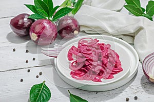 Jar with tasty pickled onions on black table. Cutlery, served meal ready to eat, trendy stand