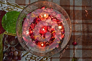 A jar is which is loaded with rose and candle on indian festival diwali deepawali with fire  on table