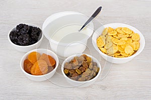 Jar of yogurt and dried fruits, corn flakes in bowls