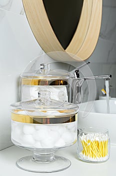 Jars with cotton balls, swabs and pads on white countertop