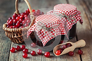 Jars of cranberries jam and basket with bog berry