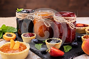 Jars with delicious summer fruits jam