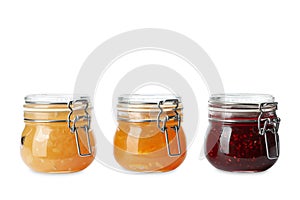 Jars of different delicious jams on background