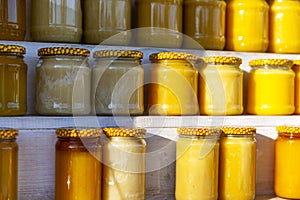 Jars with different honey on the shelves at the market. Healthy eco products