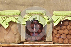 Jars with fruity compotes . Preserved fruits photo